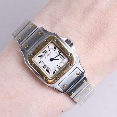 a silver and gold wrist watch on a woman ' s wrist