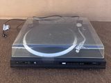 une platine posée par terre à côté d'une télécommande