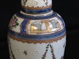 a vase with a lid that has flowers on it