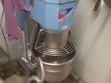 un mixeur bleu dans une cuisine, avec une serviette violette accrochée à sa poignée