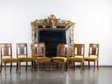 six chaises devant un miroir dans une pièce