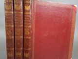 trois livres sont empilés sur une table