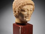 a roman marble head of a woman on a wooden stand