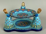 une photo d'une assiette bleue et dorée sur laquelle figure une femme