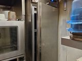 des fours en acier inoxydable dans une cuisine professionnelle, avec des casseroles et des poêles posées sur le plan de travail