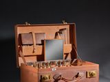 a brown suitcase with a mirror and a cloth