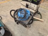 a vacuum that is sitting on the ground next to a car