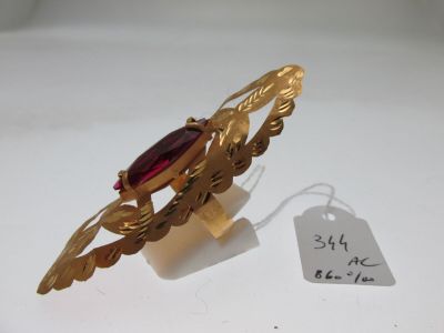 Gros plan sur une bague en or ornée d'une pierre rouge
