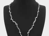 a white pearl and silver necklace on a mannequin neck