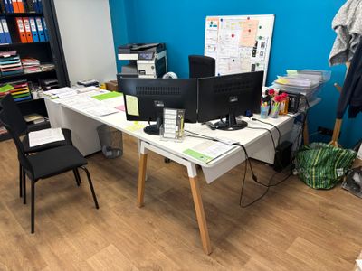 un bureau avec deux ordinateurs et une chaise devant