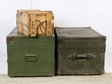 two green trunks sitting next to each other on the floor