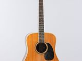 an acoustic guitar hanging from a string on a white wall