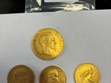 trois pièces d'or sont posées sur une feuille de papier