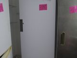 a refrigerator in the corner of a kitchen with a pink sticker on it