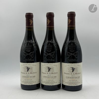 trois bouteilles de vin posées sur une table l'une à côté de l'autre