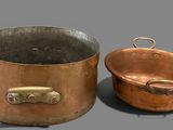 pair of copper pots and pans on a gray surface