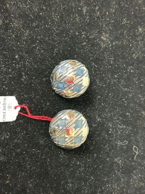 two small glass beads on a black surface with a red string