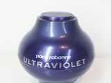 une image représentant un vase violet posé sur une surface blanche