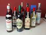 Des bouteilles de vin sont alignées sur un comptoir devant un mur rouge