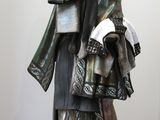 statue d'une femme tenant une pile de livres, posée sur un socle noir