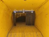 a yellow dump truck that is going through a tunnel