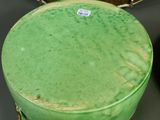 a green vase sitting on top of a table next to a bowl