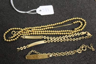trois bracelets en chaîne dorée et une étiquette sur un fond noir