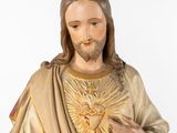 statue of jesus holding the sacred heart of jesus in his right hand