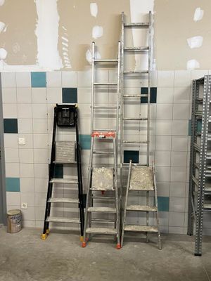 plusieurs échelles sont alignées contre un mur dans une pièce