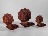 trois objets en osier sont disposés en rangée sur une surface blanche