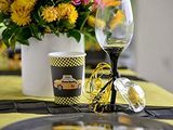 yellow and black table setting with a glass of wine and a vase of flowers