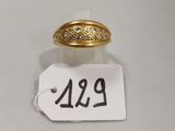 un gros plan d'une bague en or sur une étiquette de prix