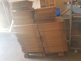 a large stack of cardboard sitting on a pallet in a garage