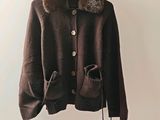 brown jacket with fur collar and cuffs hanging on a hanger
