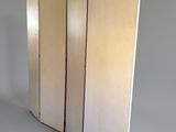 three paneled room divider in a room with a white wall