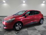une voiture rouge est garée dans une pièce au sol en damier