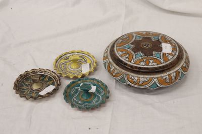 quatre pièces de poterie différentes posées sur une table