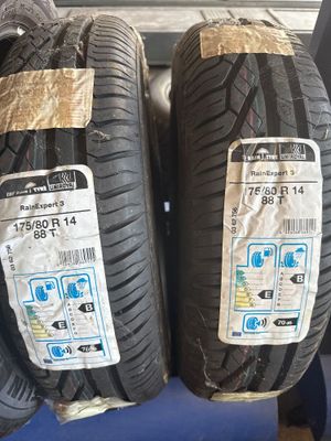 deux pneus sont empilés l'un sur l'autre sur une chaise bleue