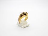 a close up of a gold ring on a white surface