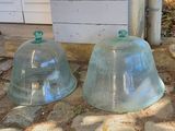 deux cloches en verre posées par terre l'une à côté de l'autre