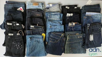 many pairs of jeans that are stacked together on a table