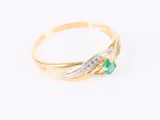 gros plan d'une bague en or avec une pierre verte