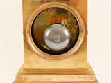 a gold clock that is sitting on a white surface