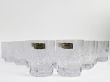 six glasses sitting on a white surface with a label on them
