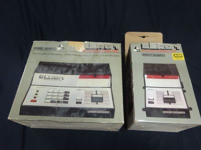 two boxes of nintendo game controllers sitting on a black surface