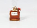 un petit flacon de parfum orné d'une fleur rouge