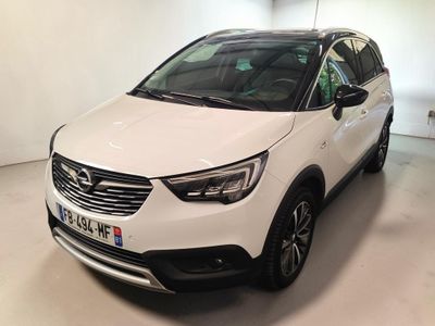 Une voiture blanche est garée dans une pièce blanche.