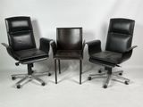 trois fauteuils de bureau en cuir noir et une chaise de bureau à roulettes