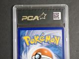 the pokemon card is in a plastic case on a table