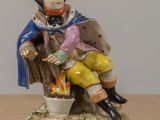 a figurine of a boy sitting on a tree stump